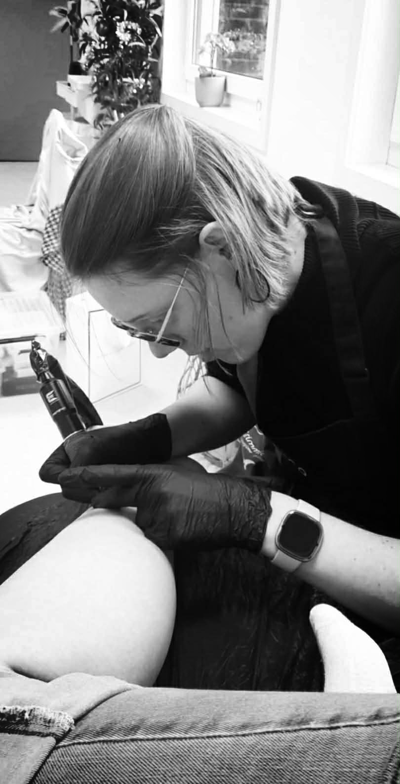 tattoo artist bezig een tattoo aan het zetten